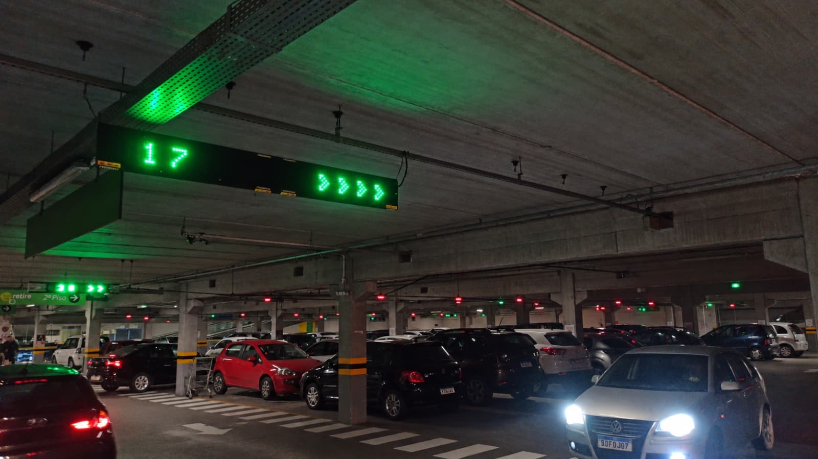 Display showing available spaces and directional arrows along the aisle