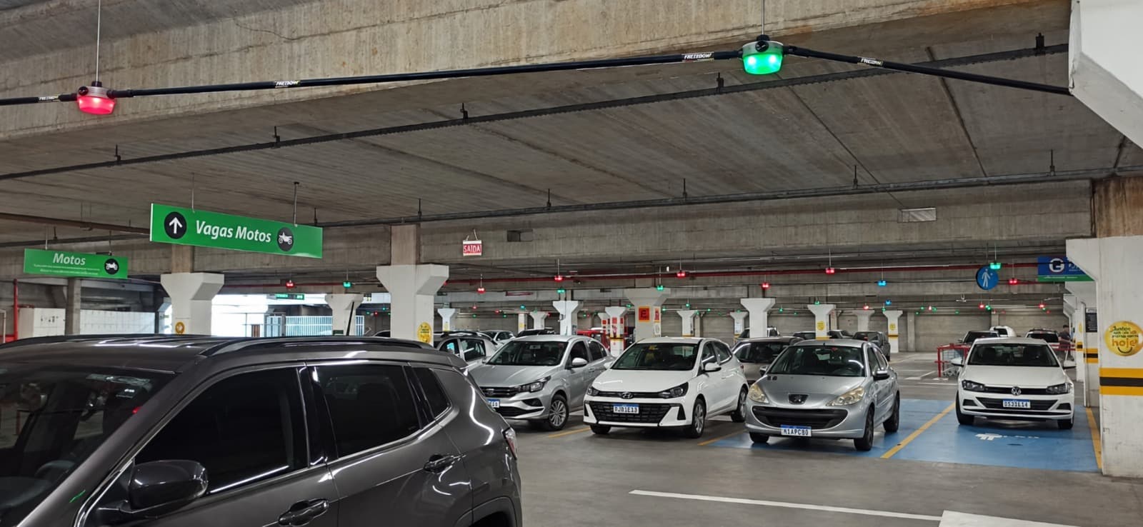 Green and red sensors above spaces in an operating car park