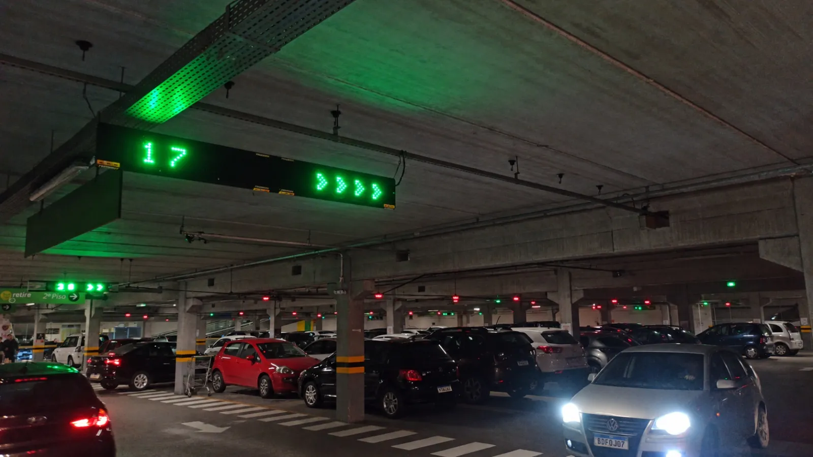 Painel com quantidade de vagas livres e setas direcionais no corredor