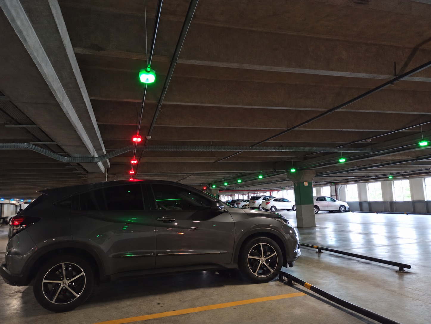 Sensores luminosos verdes e vermelhos instalados sobre as vagas